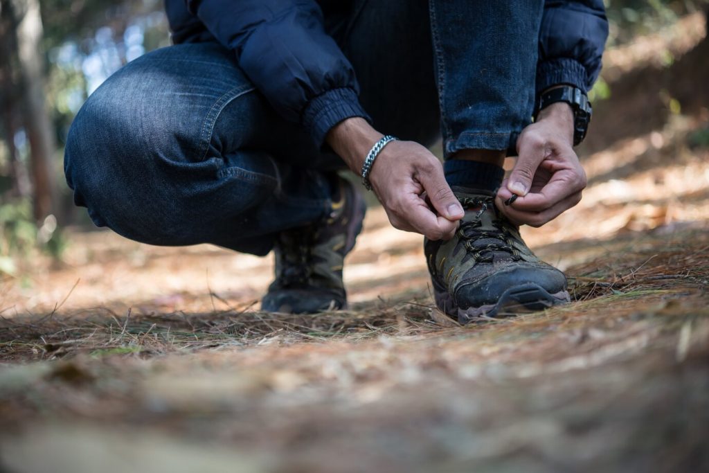 young-hiker-man-ties-laces-his-shoe-holiday-backpacking-forest_1150-1964